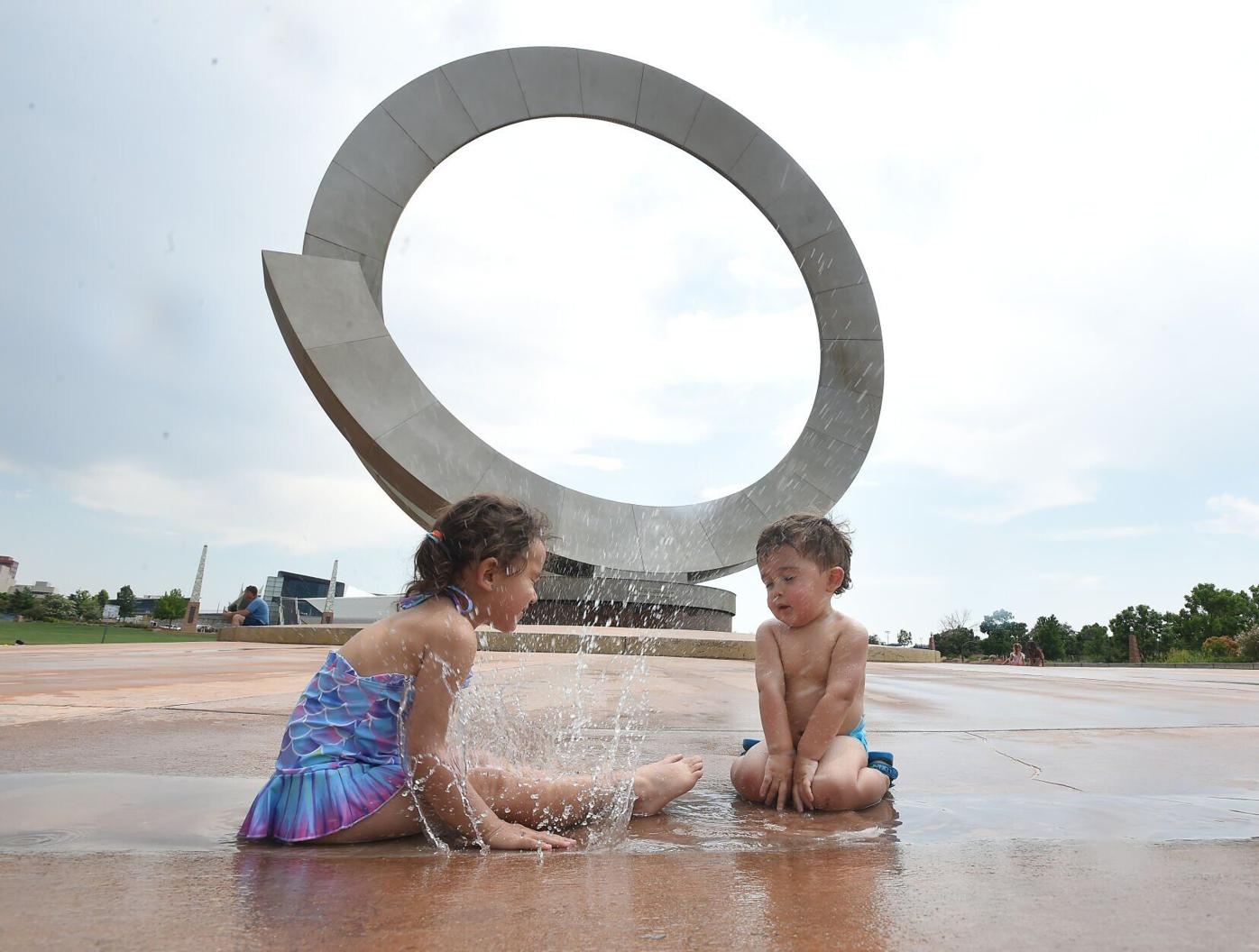 Kids cool off at the Julie Penrose Fountain on June 17