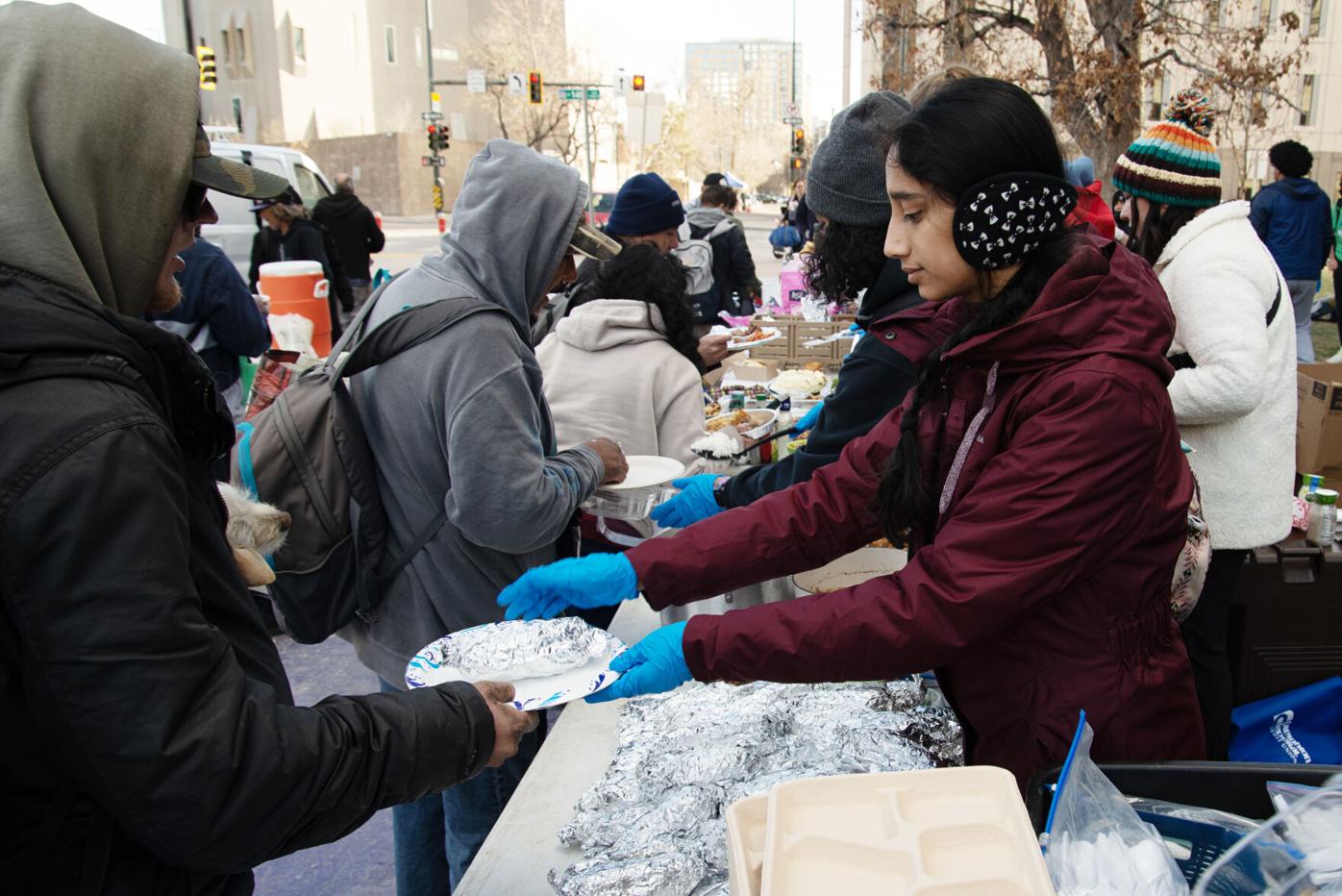 Hridya Nair, right, hands out food items to the hungry