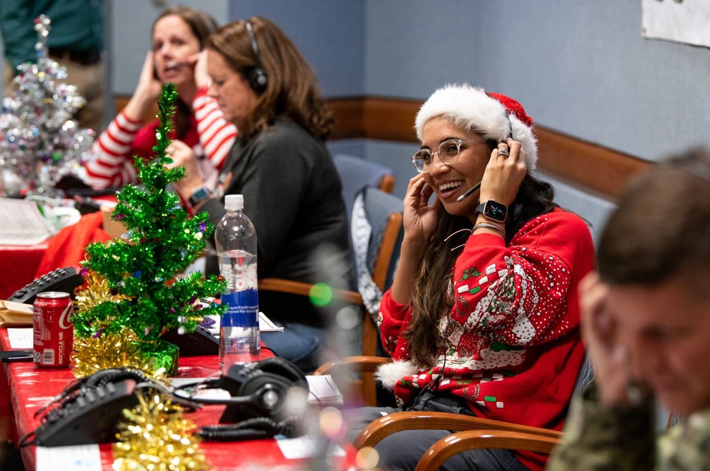 Majoraca Weber, center, speaks to a caller at the NORAD Tracks Santa Operations Center on Christmas Eve in 2022